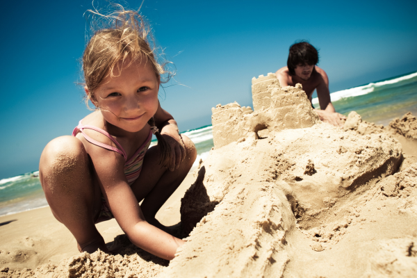 child building a sand castle on the florida panhandle.