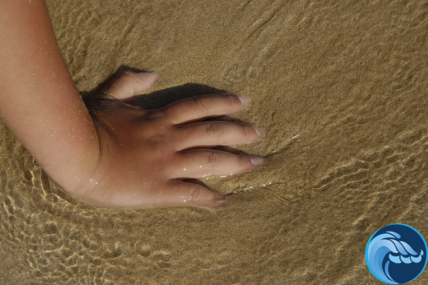 Child's hand in the sand at beach